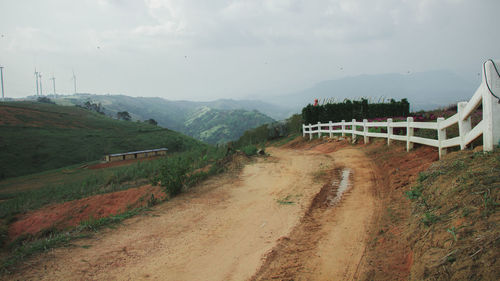Road amidst field against sky