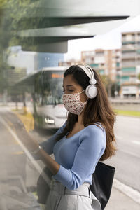 Woman standing on mobile phone in city