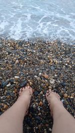 Low section of woman legs in water at beach