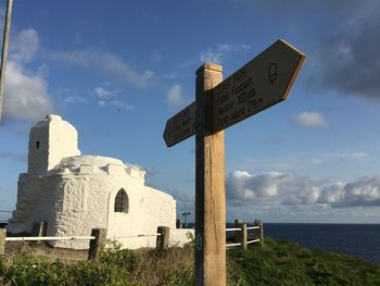 Cross by sea against sky