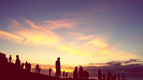 Silhouette of people against sky during sunset