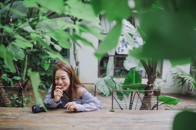 Smiling woman sitting on chair at yard