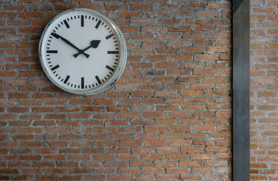 Low angle view of clock on brick wall