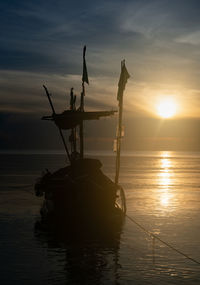 Silhouette ship in sea against sky during sunset