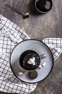 Quick chocolate cake mug with marshmallows on a plate on the table top and vertical view