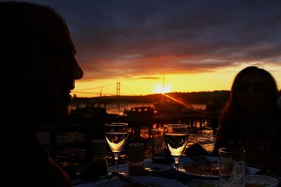 Portrait of woman drinking glass at sunset