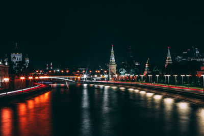 View of illuminated bridge over river at night