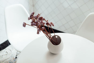 Close-up of vase on white table at home