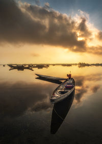 Boat in sea against sky during sunset