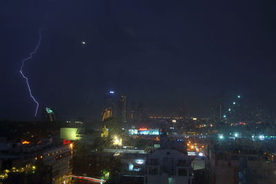 Illuminated city against sky at night