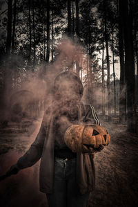 Digital composite image of man holding camera in forest