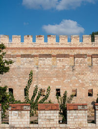 Low angle view of brick wall against building