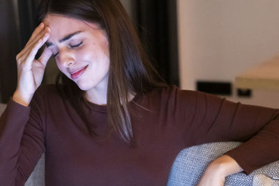 Close-up of young woman sitting at home