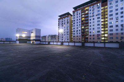 Illuminated buildings against sky at dusk