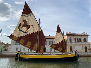 People sailing on sailboat against sky