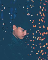 Portrait of young woman looking at illuminated lights