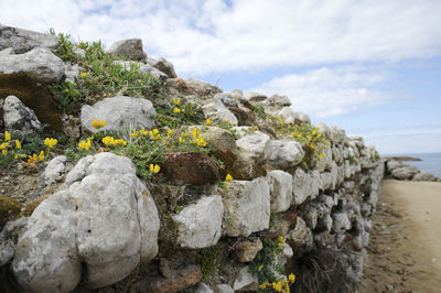 Rocks by sea against sky