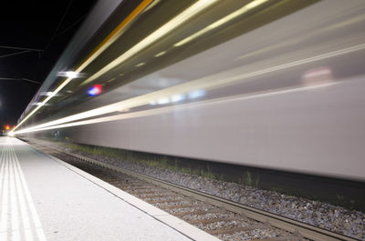 Train at railroad station platform at night