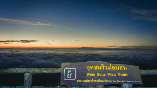 Information sign against sky during sunset