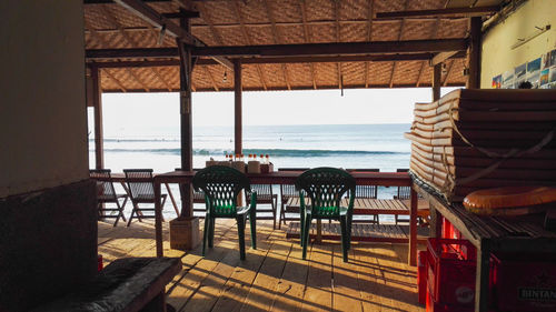 Chairs and tables in restaurant by sea against sky