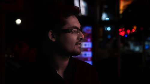 Close-up of young man in illuminated room