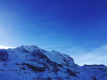 Scenic view of snowcapped mountains against blue sky