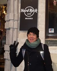 Portrait of smiling young woman standing against text