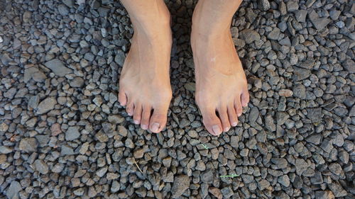 Low section of person standing on stones