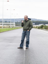 Man smoking while standing on street during winter