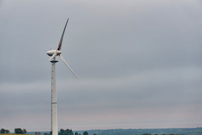 Wind turbines in sea against sky