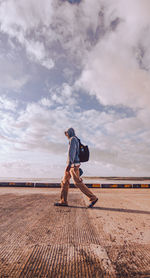 Full length of man standing on shore against sky