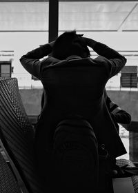 Rear view of woman sitting at airport