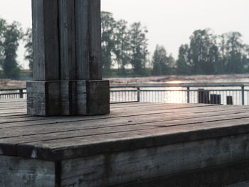 Close-up of pier over lake against sky