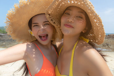 Portrait of happy woman wearing hat on beach