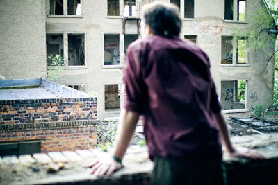 Rear view of man in front of building