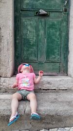 Close-up of girl sitting on front stoop