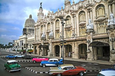 Cars on road by building against sky