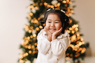 Portrait of an asian emotional little girl child having fun on christmas holiday in decorated house