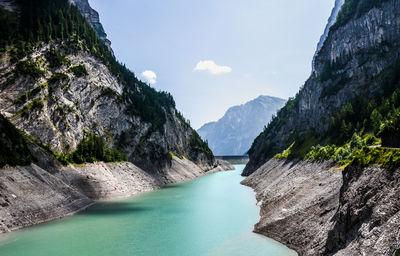 Scenic view of river amidst mountains against sky