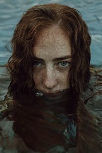 Close-up portrait of young woman in lake