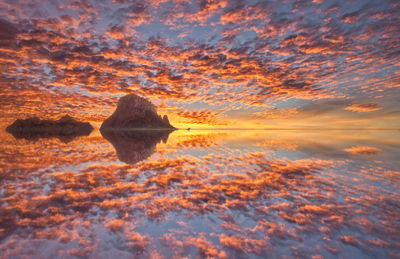 Scenic view of sea against dramatic sky during sunset