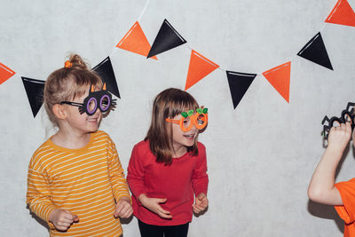 Children in carnival masks play and scare each other. friends at home spending halloween together