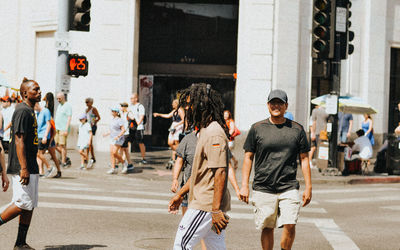 Group of people walking on road along buildings