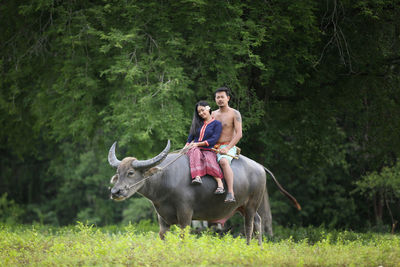 Young man riding horse on field