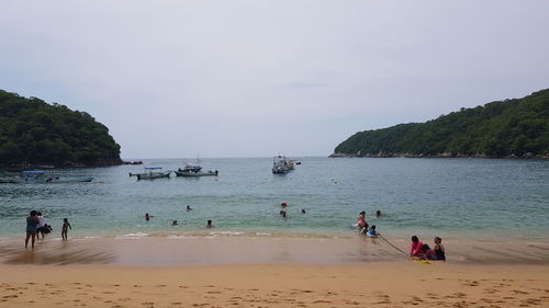 People at beach against sky