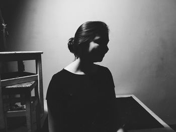 Young woman standing against wall