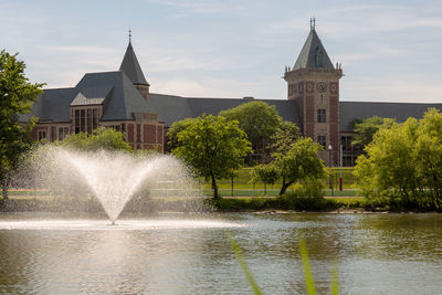 Fountain by building against sky