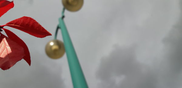 Low angle view of red toy hanging against sky