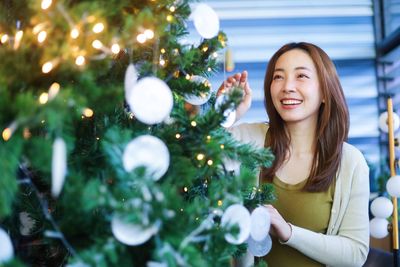 Portrait of young woman holding christmas tree