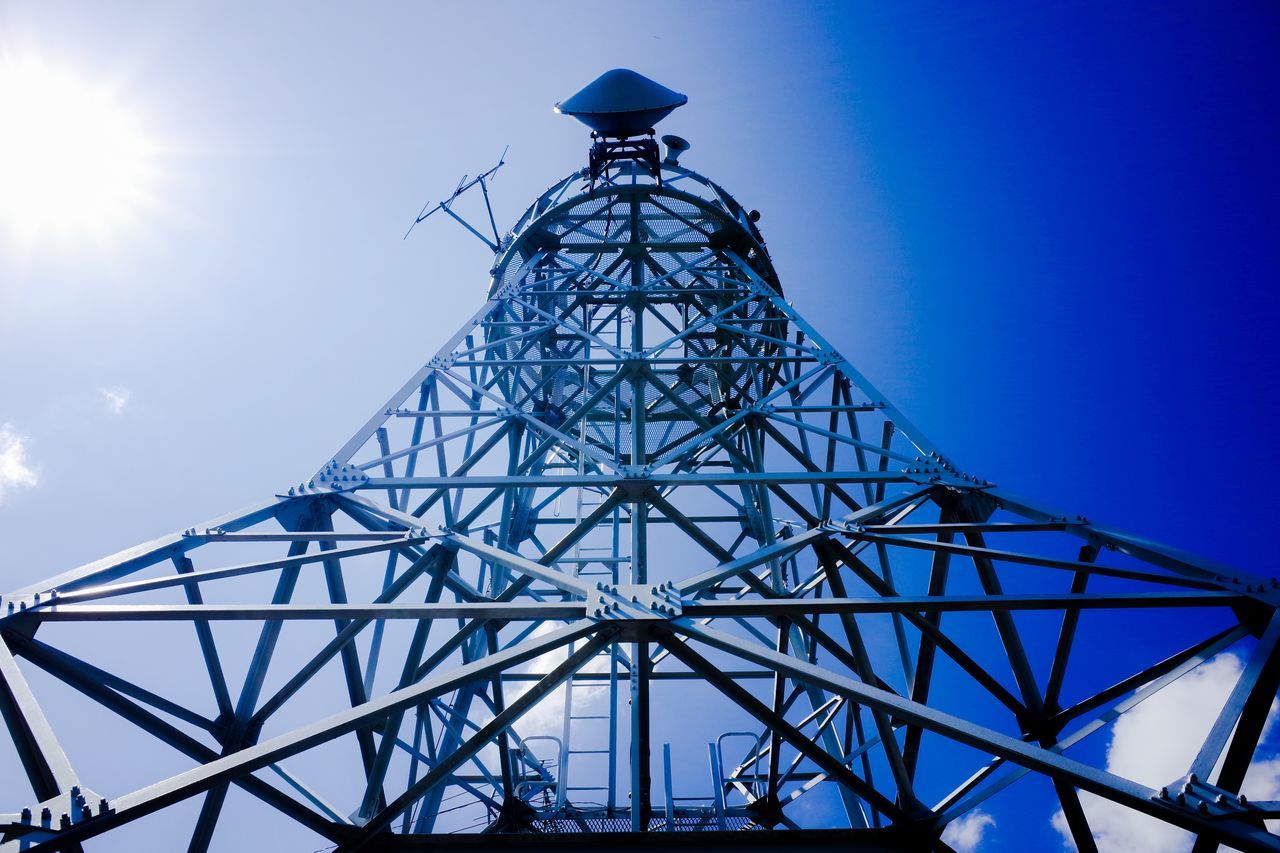 low angle view, blue, clear sky, sky, built structure, metal, lighting equipment, electricity, architecture, sunlight, connection, silhouette, street light, day, metallic, no people, outdoors, technology, sun, tower